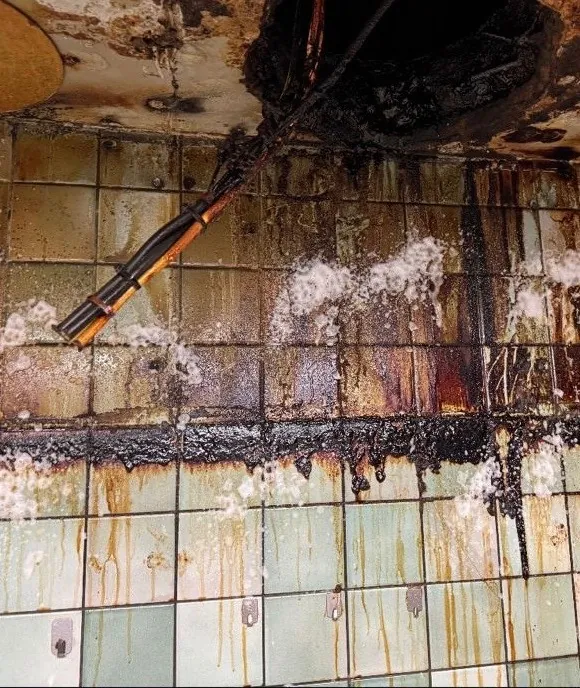 Pared de la cocina de un local de hostelería con grasa acumulada antes de la limpieza