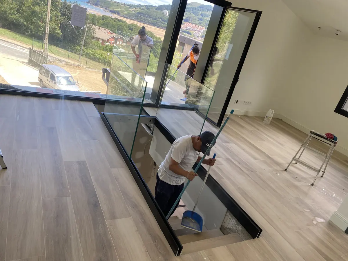 Operario de Ipar Clean limpiando la barandilla de cristal de una vivienda nueva