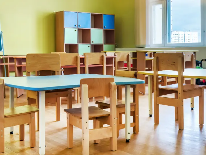 Aula infantil limpia con mesas y sillas ordenadas