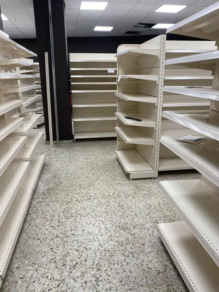 Pasillo de estanterías de un local comercial limpio por Ipar Clean
