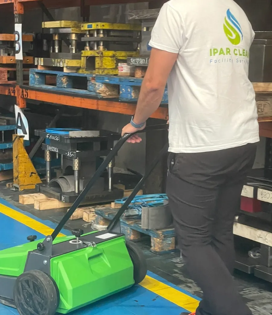 Operario de Ipar Clean pasando una barredora en un pabellón industrial
