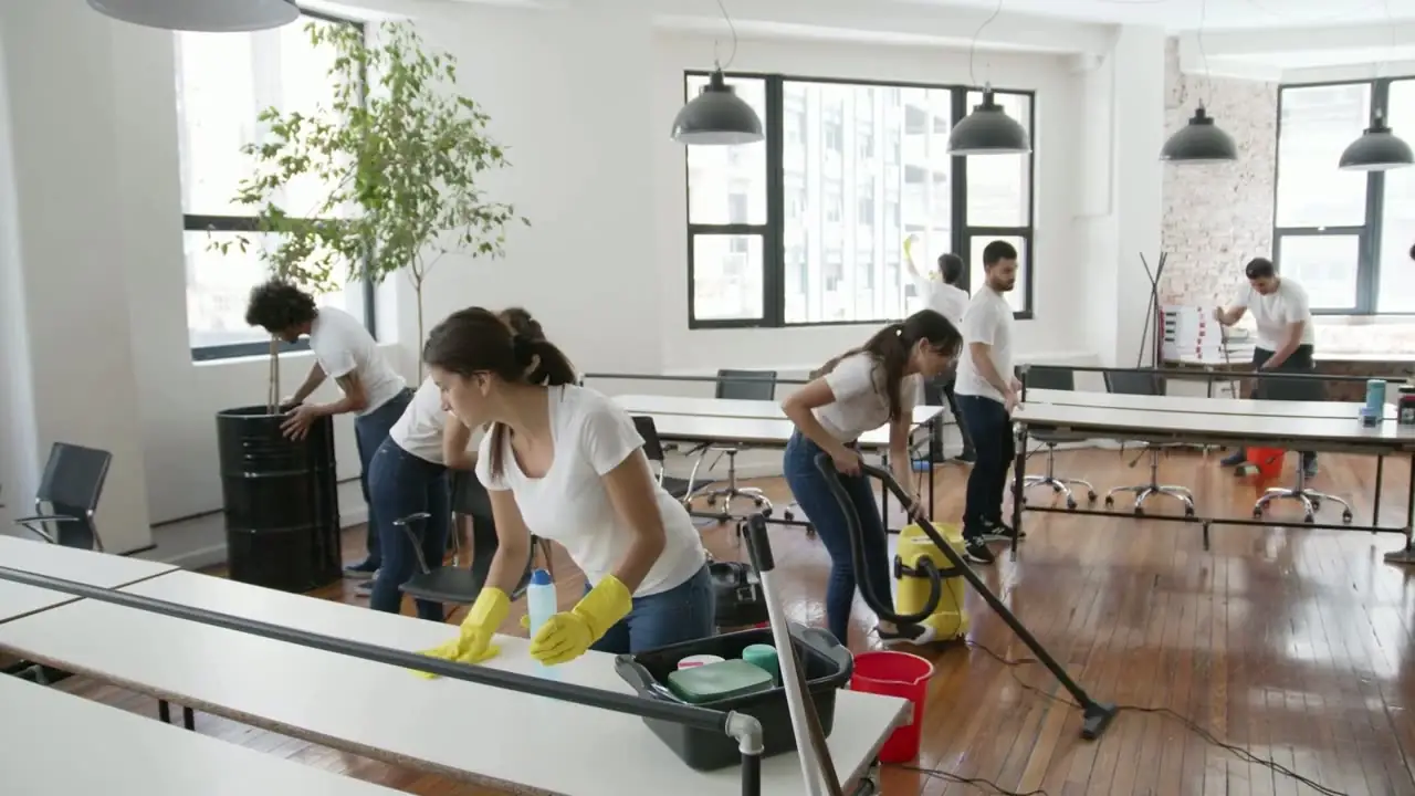 Equipo de limpieza profesional limpiando una oficina diáfana